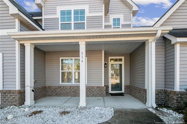 snow covered property entrance featuring a porch