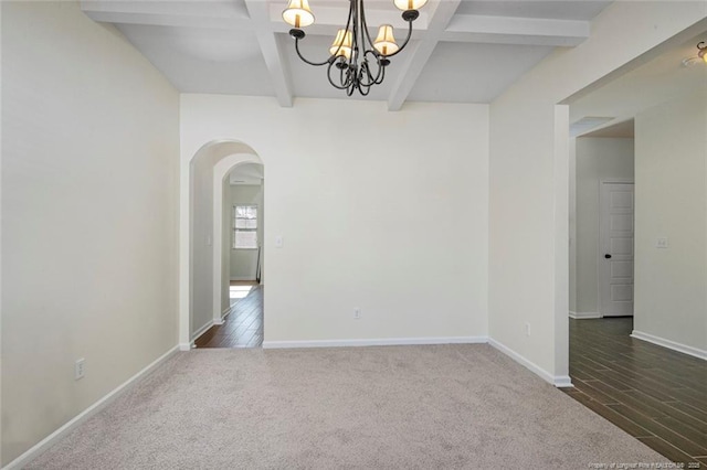 carpeted spare room featuring a chandelier and beam ceiling