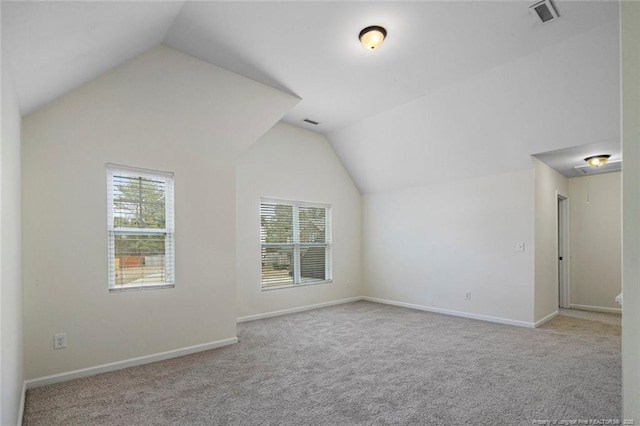 bonus room with lofted ceiling and light colored carpet