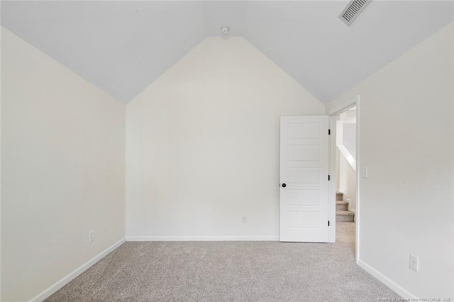 additional living space featuring lofted ceiling and light carpet