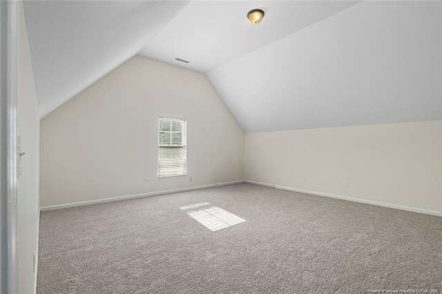 bonus room with light carpet and vaulted ceiling