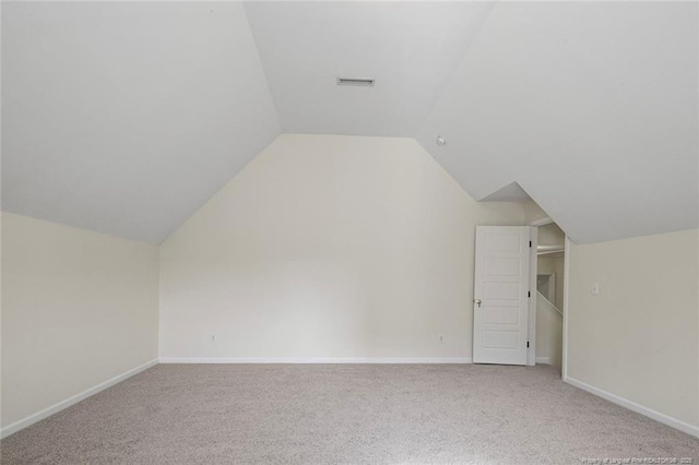 additional living space with vaulted ceiling and carpet floors