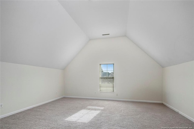 additional living space with vaulted ceiling and carpet