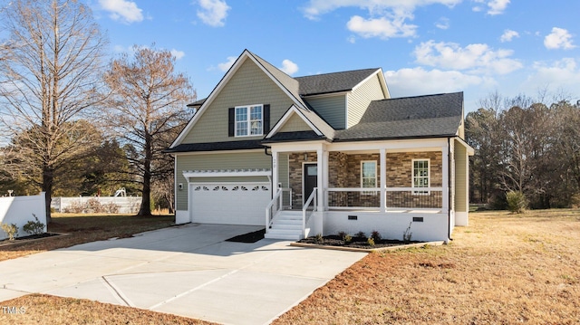 view of front of property featuring a garage, covered porch, and a front lawn