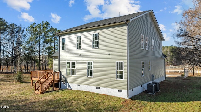 rear view of property with a wooden deck, a yard, and central air condition unit