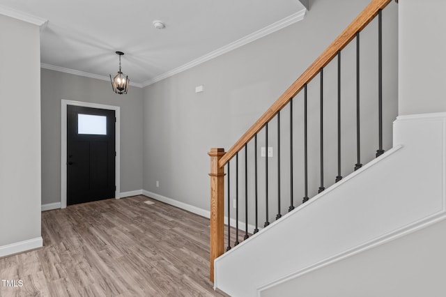 entryway featuring crown molding, light hardwood / wood-style flooring, and a notable chandelier