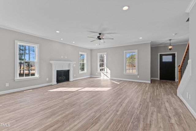 unfurnished living room featuring ceiling fan, ornamental molding, and light hardwood / wood-style floors