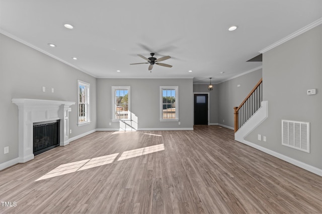 unfurnished living room with crown molding, ceiling fan, and light hardwood / wood-style flooring