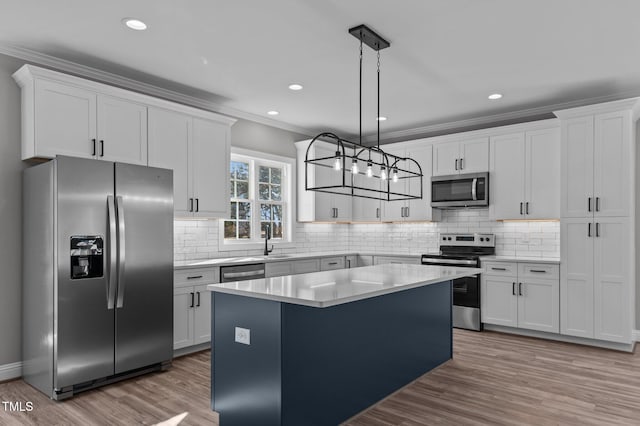 kitchen featuring white cabinetry, stainless steel appliances, a center island, and hanging light fixtures