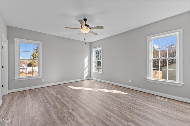 unfurnished room featuring ceiling fan, plenty of natural light, and light hardwood / wood-style floors