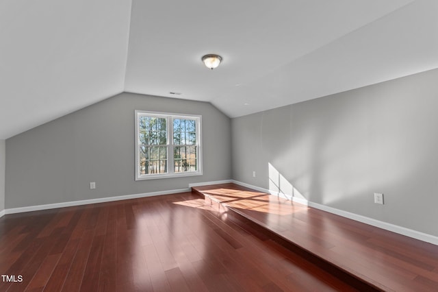 bonus room with vaulted ceiling and dark hardwood / wood-style floors