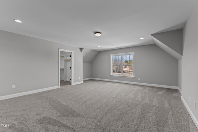 additional living space featuring carpet floors and vaulted ceiling