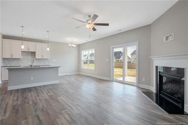 363 Lyman Dr, Fayetteville, NC 28312 - unfurnished living room with wood-type flooring, sink, and ceiling fan with notable chandelier