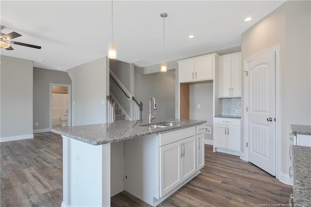 363 Lyman Dr, Fayetteville, NC 28312 - kitchen featuring white cabinetry, sink, hanging light fixtures, a kitchen island with sink, and light stone countertops