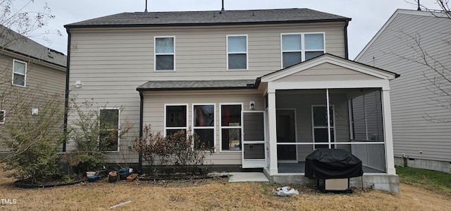 back of house with a sunroom and a lawn