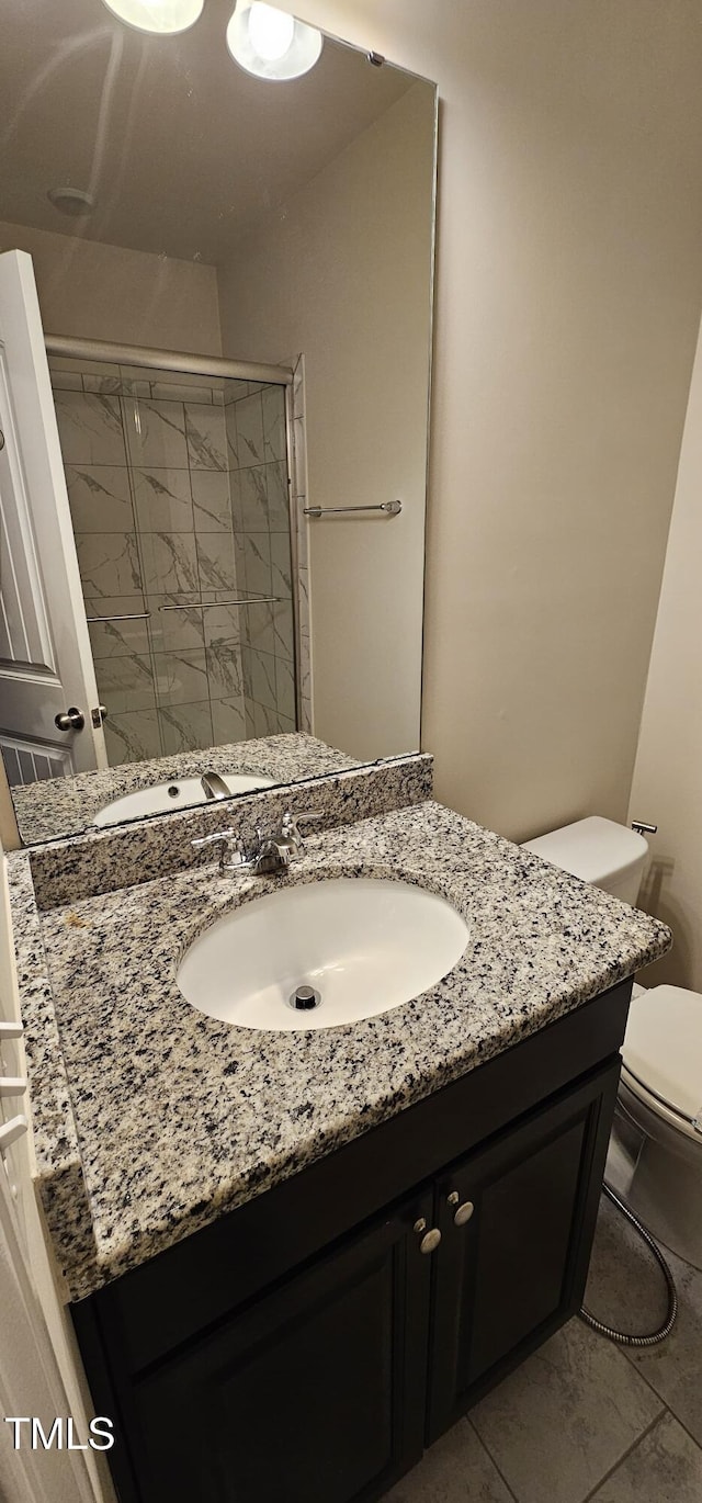 bathroom with toilet, vanity, and walk in shower