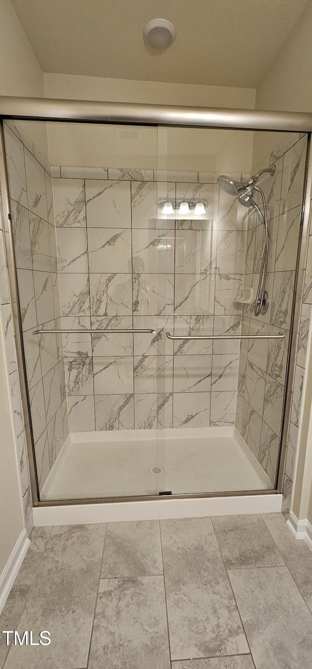 bathroom featuring a shower with shower door