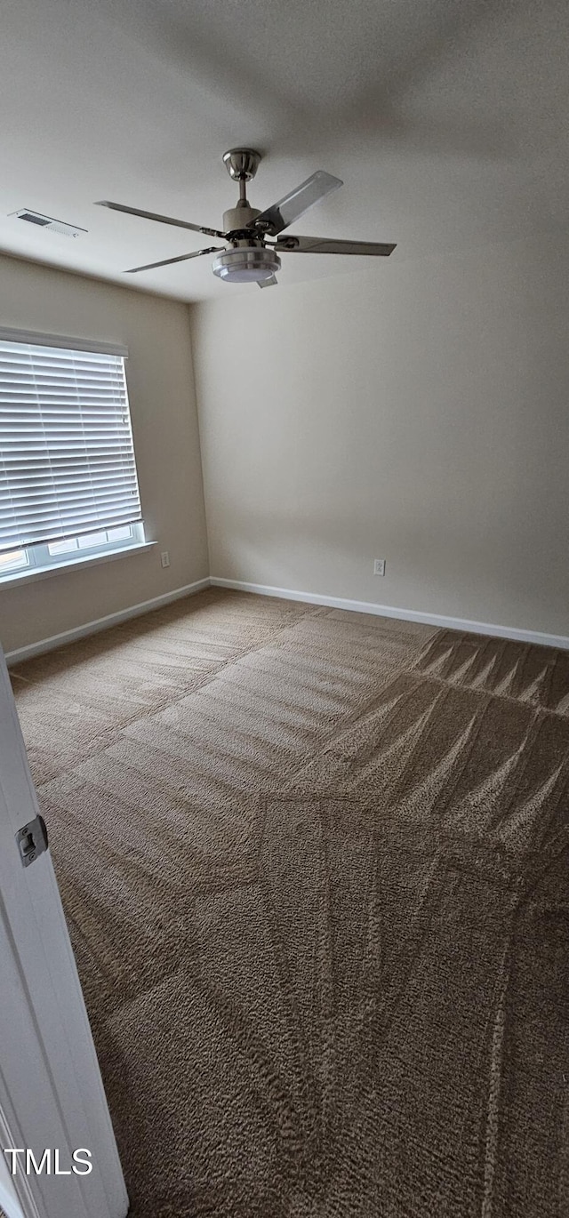 spare room with carpet floors and ceiling fan