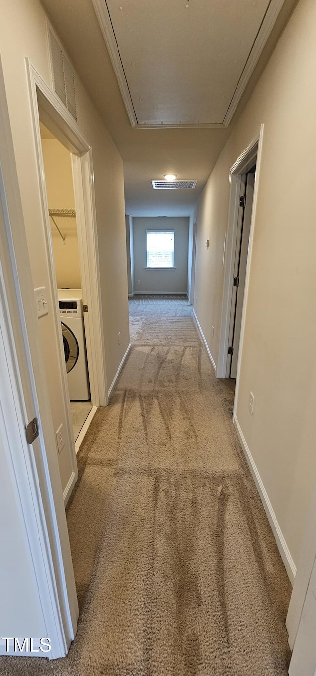 hall featuring washer / clothes dryer and light colored carpet