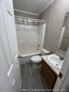 full bathroom featuring toilet, wood-type flooring, a textured ceiling, shower / washtub combination, and vanity