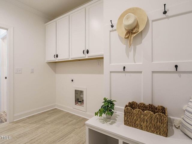 laundry area with cabinets, crown molding, hookup for an electric dryer, and light wood-type flooring