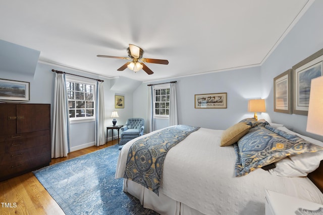 bedroom with hardwood / wood-style floors, ornamental molding, and ceiling fan