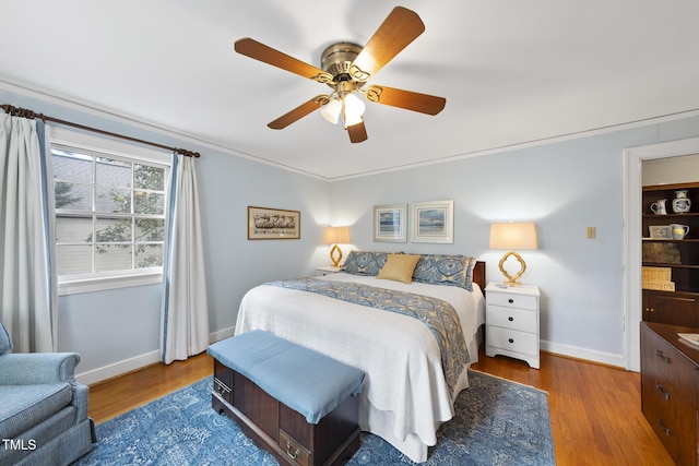 bedroom with hardwood / wood-style flooring, ceiling fan, and ornamental molding