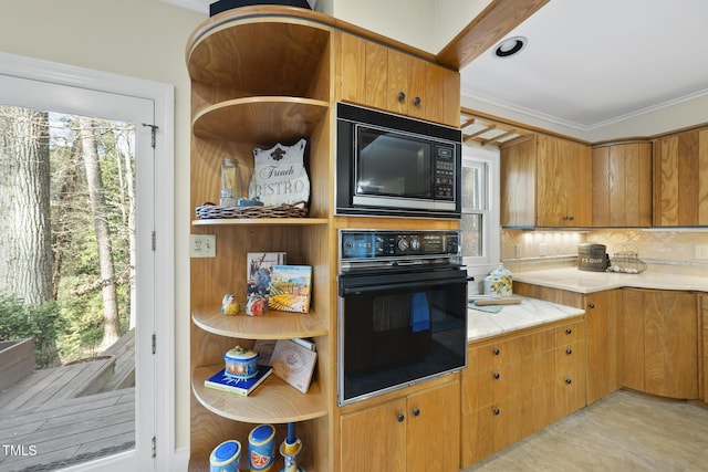 kitchen featuring ornamental molding, a healthy amount of sunlight, decorative backsplash, and black appliances