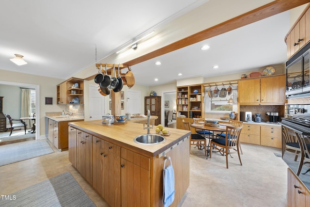 kitchen with sink, a center island with sink, and backsplash