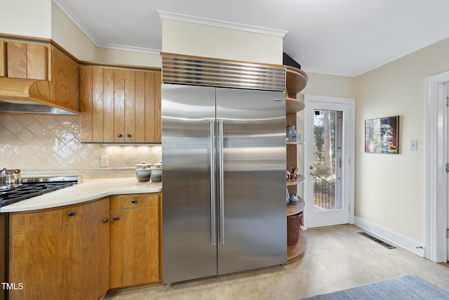 kitchen with crown molding, decorative backsplash, and stainless steel built in fridge