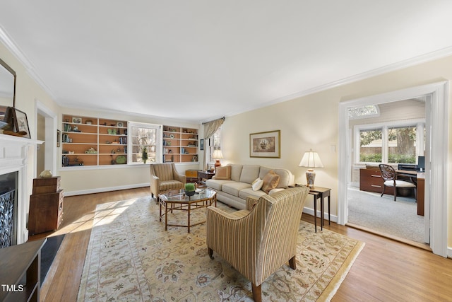 living room featuring crown molding, built in shelves, and hardwood / wood-style flooring