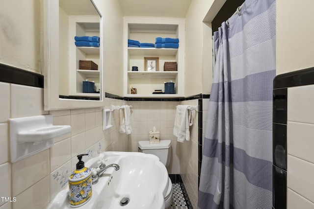 bathroom with toilet and tile walls