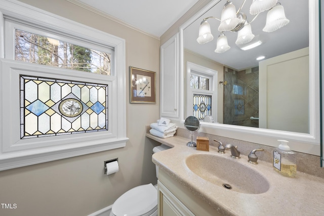 bathroom featuring a tile shower, vanity, ornamental molding, toilet, and an inviting chandelier