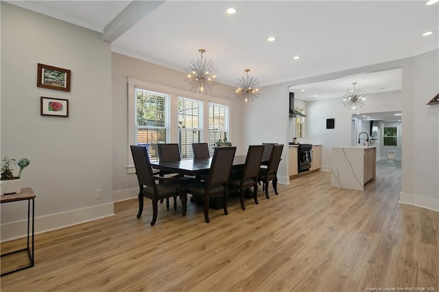 dining area featuring a notable chandelier, crown molding, and light wood-type flooring