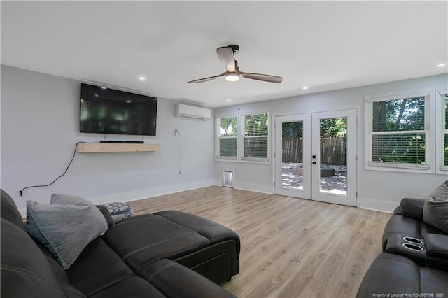 living room featuring a wall mounted air conditioner, light hardwood / wood-style floors, french doors, and a healthy amount of sunlight