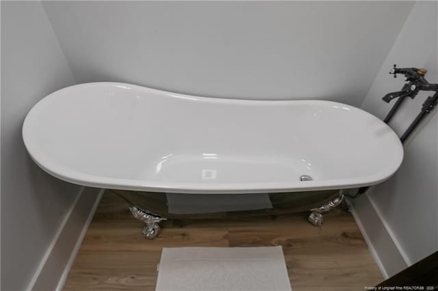 bathroom with wood-type flooring and a tub