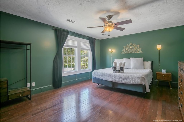 bedroom featuring ceiling fan, a textured ceiling, and dark hardwood / wood-style flooring