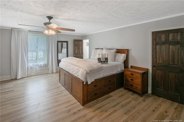 bedroom featuring crown molding, light hardwood / wood-style floors, and a textured ceiling