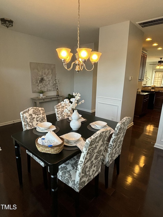 dining space with an inviting chandelier and dark hardwood / wood-style flooring