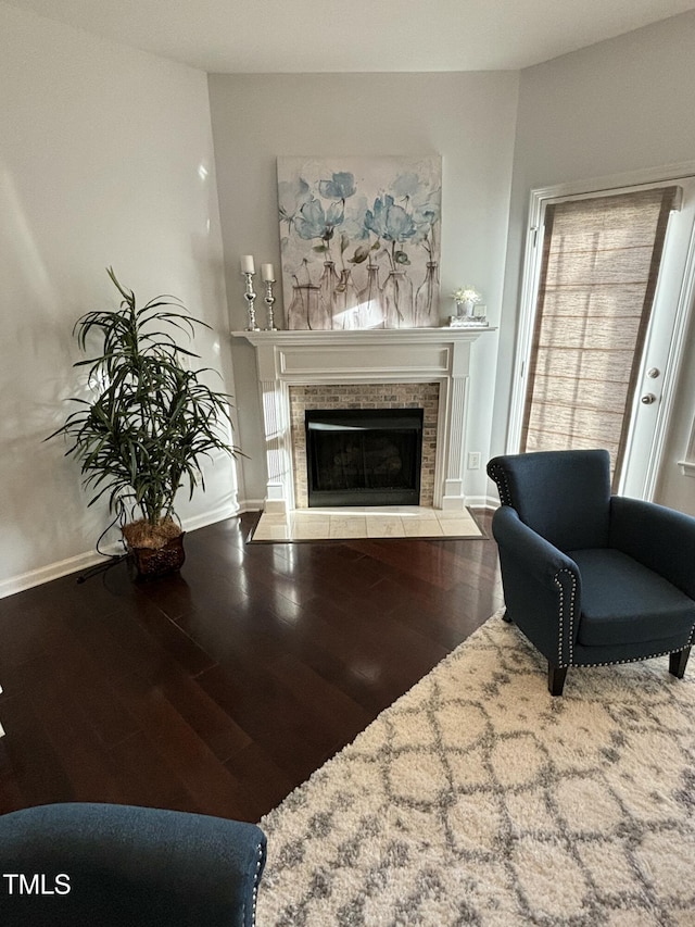 living room featuring hardwood / wood-style flooring and a tiled fireplace