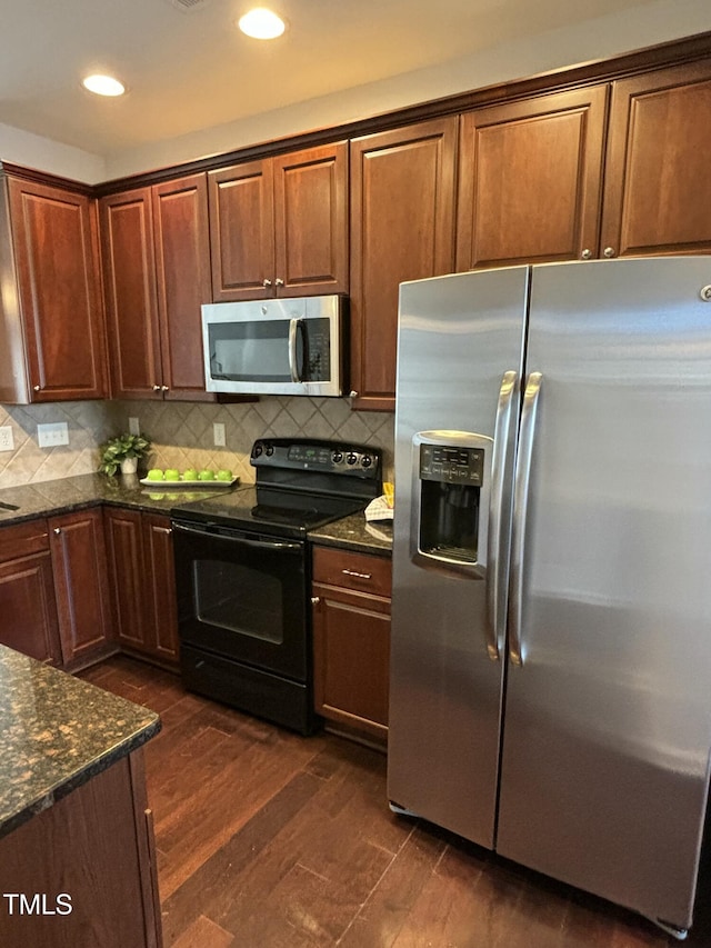 kitchen featuring dark stone countertops, tasteful backsplash, dark hardwood / wood-style floors, and appliances with stainless steel finishes