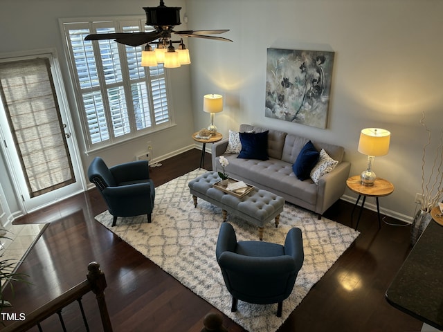 living room featuring dark wood-type flooring and ceiling fan