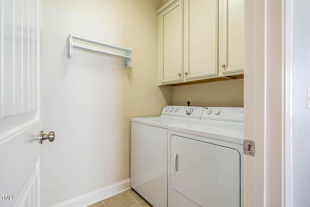 laundry room featuring cabinets, light tile patterned floors, and washer and dryer