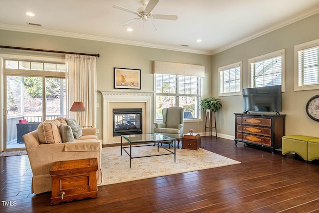 living room with dark wood-type flooring, ornamental molding, and ceiling fan