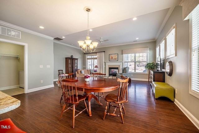 dining area with an inviting chandelier, ornamental molding, and dark hardwood / wood-style floors