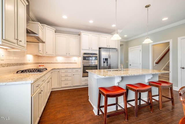 kitchen featuring stainless steel appliances, hanging light fixtures, a kitchen island with sink, and a breakfast bar