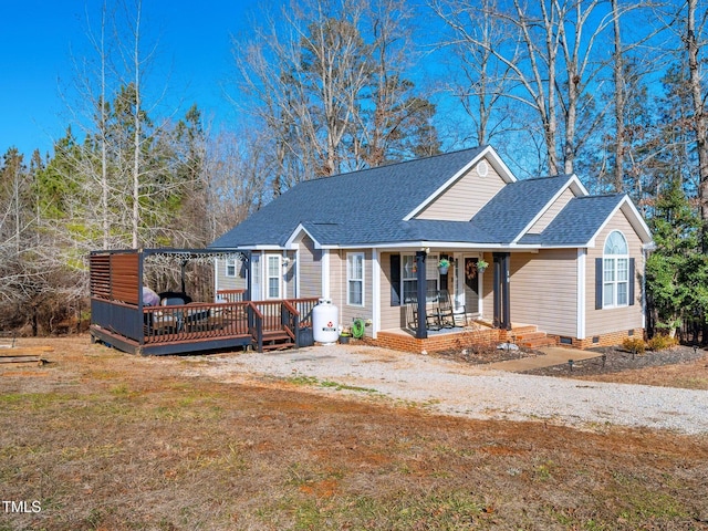 view of front of house featuring a wooden deck, covered porch, and a front lawn