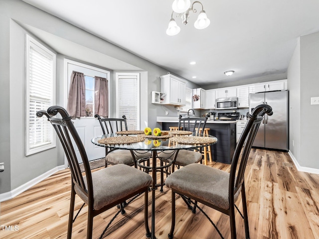 dining space featuring a chandelier and light wood-type flooring