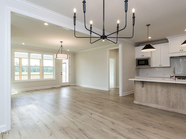 1813 Bright Lantern Way, Wendell, NC 27591 - kitchen featuring stainless steel microwave, light countertops, ornamental molding, a chandelier, and backsplash