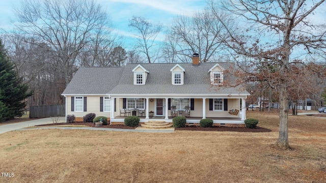 cape cod home with a front yard and a porch